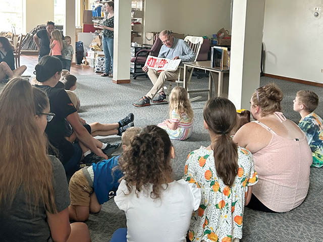 Assemblyman Barclay reading from a children's book to a small crowd of children and parents