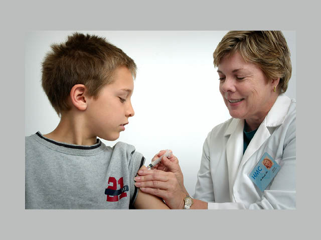 A doctor giving a young boy an immunization