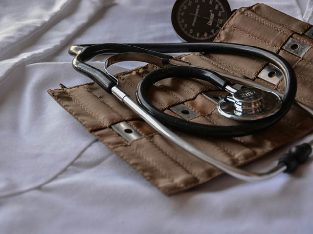 A photograph of a stethoscope and blood pressure cuff on a white sheet