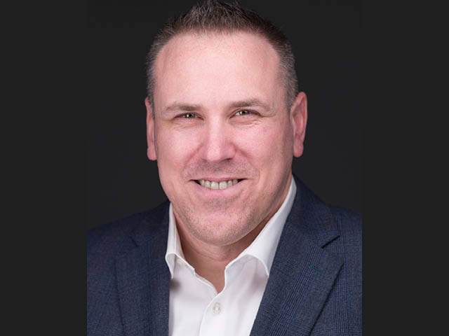 Headshot of a white man in a suit