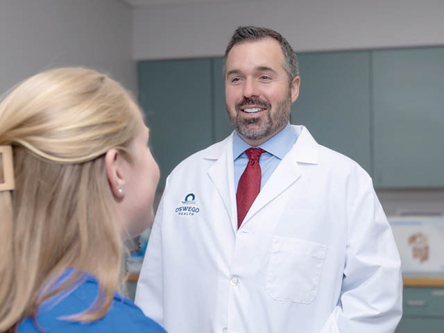 A male doctor at Oswego Health talking with a patient