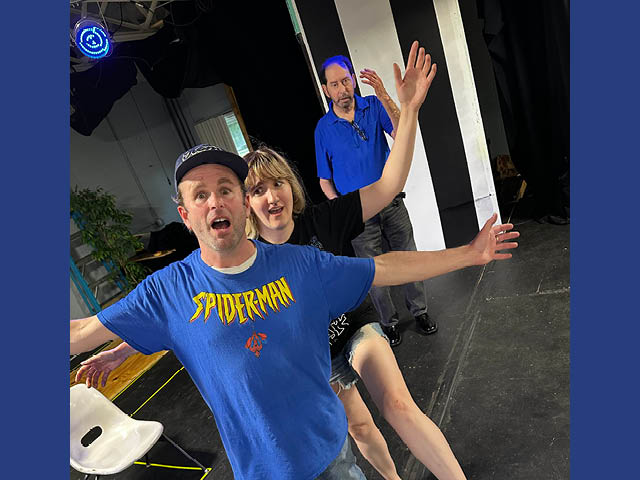 Three people with their arms outstretched