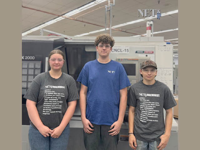 Three high school kids standing in the Net and Die factory