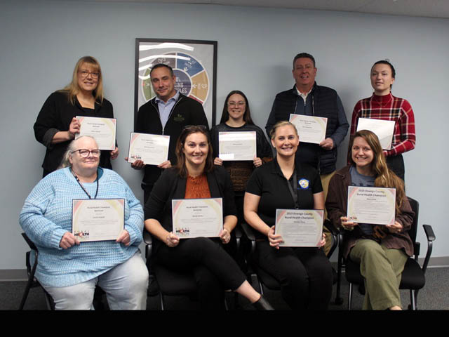 A group of men and women in two rows, each holding their own certificate