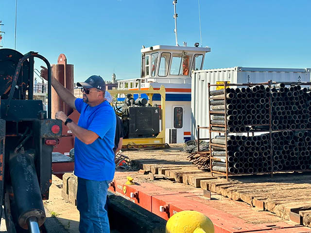 A man standing at the dock next to the fireworks barge