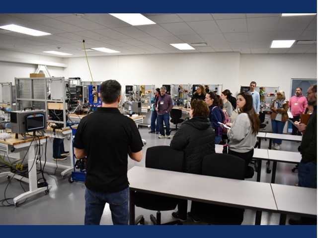 Adults standing in a room full of hands on educational equipment