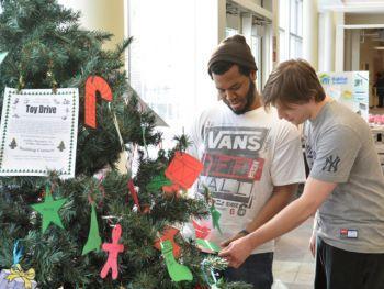 Spirit of the season -- In SUNY Oswego&#039;s Marano Campus Center, students Alain Pierre-Lys, left, a junior majoring in communication and social interaction, and Adam Wilmot, a junior economics major, consider what gifts to buy for local children during the college&#039;s 27th annual toy drive.