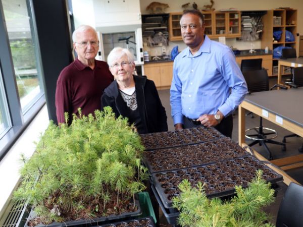 Rooting for trees -- From left, Arizona residents and New York state canal system boaters George and Jane Pauk join SUNY Oswego&#039;s Kamal Mohamed in a lab at Rice Creek Field Station, where white oak seeds are germinating and white pine seedlings are growing for the Pauks&#039; Canal Forest Restoration Project.