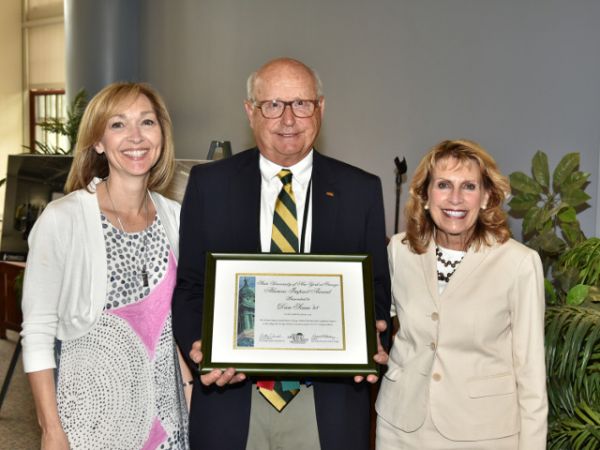 Alumnus makes impact -- Dan Scaia (center), a 1968 SUNY Oswego graduate and member of the Oswego Alumni Association’s Board of Directors, received the Alumni Impact Award during June&#039;s Reunion activities. Oswego Alumni Association President Lisa Marceau Schnorr (left) and college President Deborah F. Stanley congratulate him on the honor recognizing his decades of service and leadership.